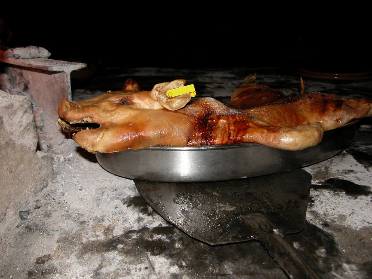 Sala del asador con mesas de madera junto al fuego